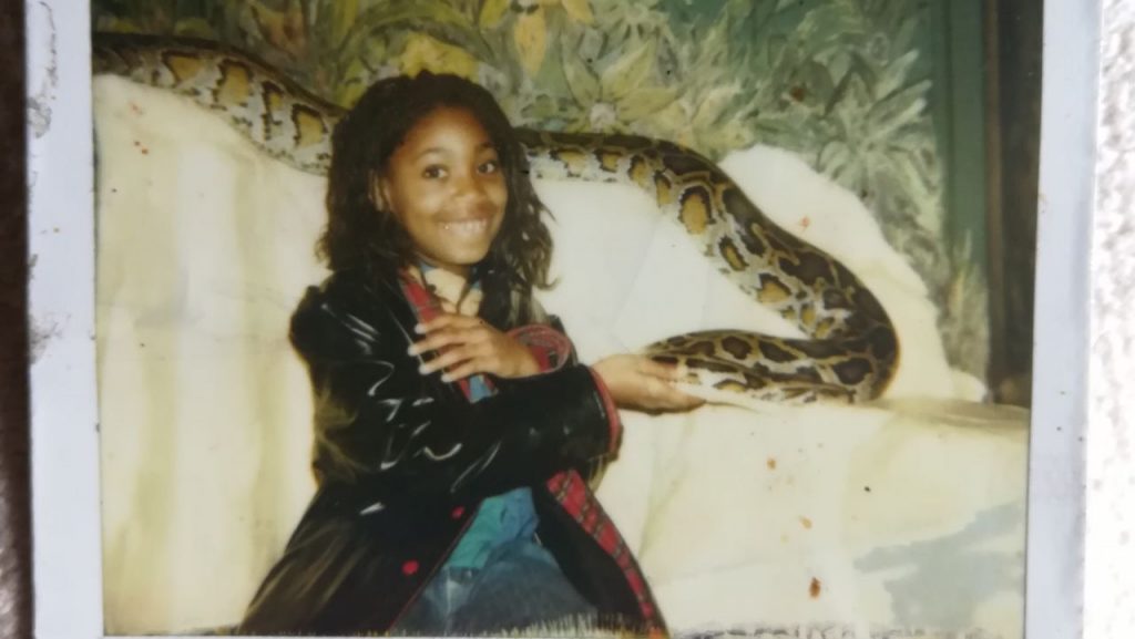 An old photo shows Daddypuss Rex, author of the essay, as a teenager. Next to them is a boa constrictor. They caress the snake and smile into the camera.
