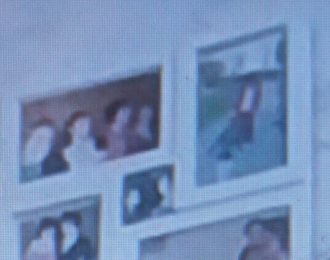 This is a photo that is out of focus. It captures a small section of a wall where there are what appears to be family photos hanging.